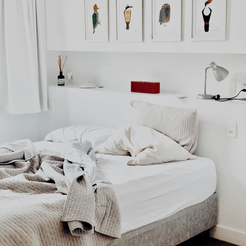 Contemporary bedroom design featuring art prints and cozy bedding for a warm ambiance.